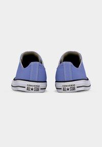 Ζεύγος ανοιχτόμπλε χαμηλά sneakers Converse All Star, φαίνεται από πίσω σε λευκό φόντο.