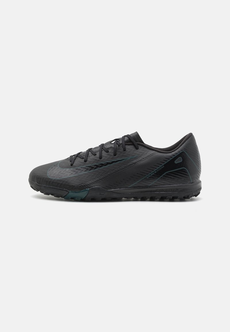 Black athletic shoe with textured synthetic upper, flat laces, and a rubber outsole featuring small studs for traction. Minimal design accents.