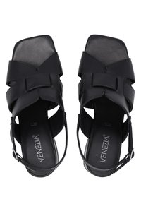 Zwarte leren sandalen met een vierkante neus, open zijkanten en een centrale strikdetail. Voorzien van een slingbackband en textuur-inlagen.