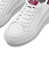 Witte leren sneakers met gestructureerde bordeauxrode accenten, een ronde neus, een platte witte rubberen zool en gevlochten witte veters.