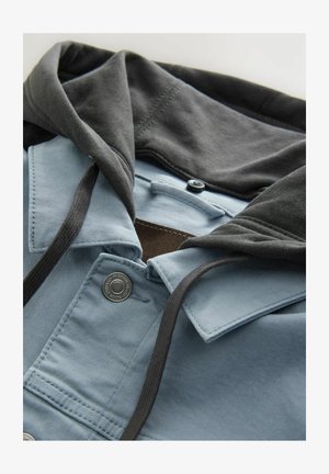 Mikina s kapucí v světle modré a tmavě šedé barvě, vyrobená z bavlny. Má zapínání na knoflíky, šňůrky a jemný materiál.