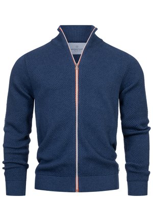 Gebreide ritsvest in donkerblauw met een gestructureerd patroon, contrasterende oranje en grijze rits, en geribbelde mouwen en onderkant.