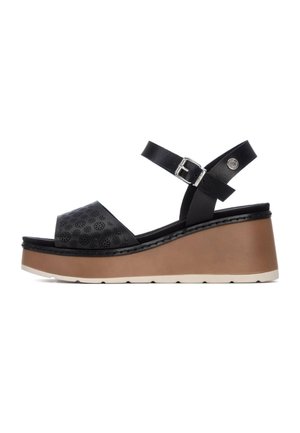 Sandali zeppa neri con tomaia traforata, cinturino regolabile alla caviglia e tacco spesso marrone. Materiale in finta pelle con suola bianca a contrasto.