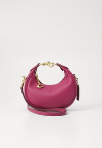 Round pink leather handbag with a smooth texture, gold hardware accents, detachable shoulder strap, and curved handles.