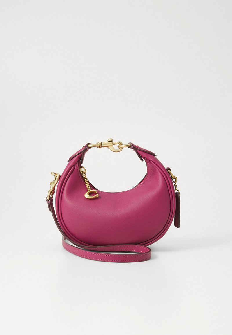 Round pink leather handbag with a smooth texture, gold hardware accents, detachable shoulder strap, and curved handles.