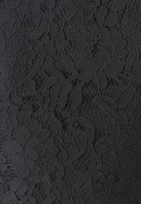 Černá krajka s květinovým vzorem, zahrnující různé listy a okvětní lístky, texturovaný povrch a složité detaily po celém povrchu.