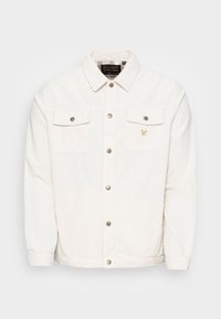 White corduroy jacket featuring a button-front closure, two chest pockets with flaps, and a small embroidered logo on the left side.
