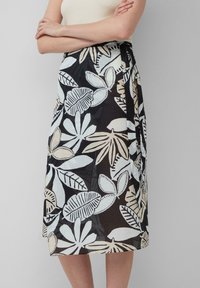 Zwarte rok met een bloemenpatroon in lichtblauw en beige. Lichtgewicht stof, knielang, met een strik in de taille.