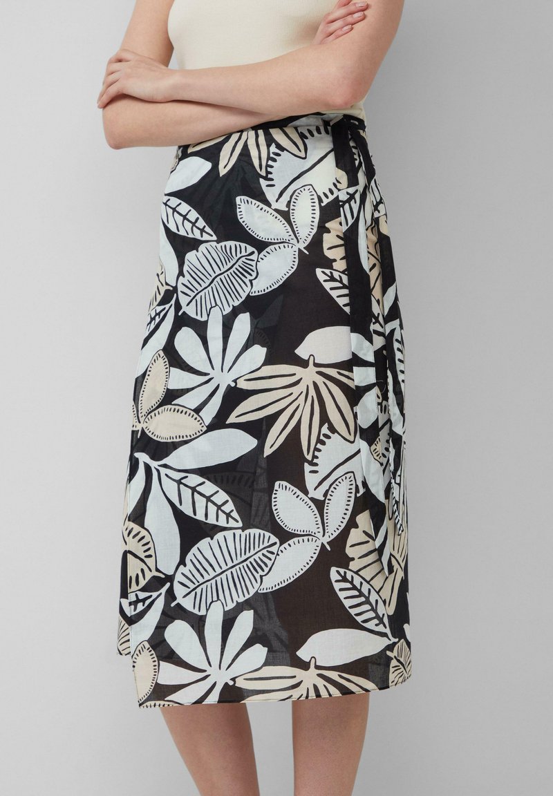 Zwarte rok met een bloemenpatroon in lichtblauw en beige. Lichtgewicht stof, knielang, met een strik in de taille.