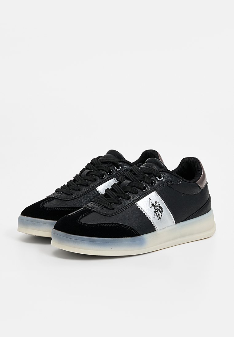 Zapatillas negras con parte superior de cuero liso y ante, franjas plateadas y suela de goma. Presentan un logo en el lateral y cordones redondos.