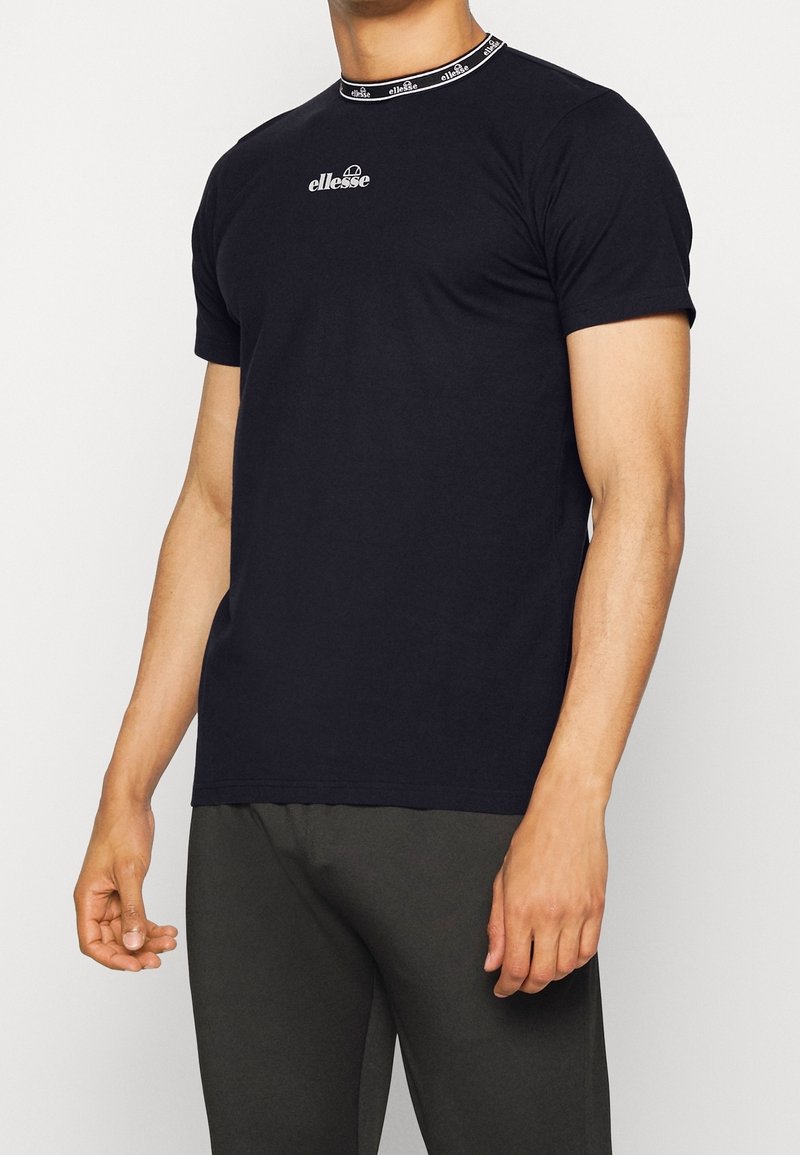 Svart t-shirt i bomull med rund halsringning och kontrasterande kant. Centralt logotypdesign. Kort ärm, avslappnad passform.