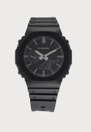 Черен ръчен часовник G-Shock с аналогови стрелки, цифров дисплей, циферблат за деня и черна каишка от смола.