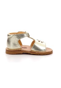 Sandalo in pelle metallica dorata con design open toe, cinturino regolabile e suola in tessuto marrone. Presenta dettagli floreali a intaglio.