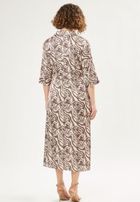 Braun- und crèmefarbener Midi-Kleid mit Muster, einem Kragen, Dreiviertelärmeln und einer taillierten Taille, das ein fließendes Textilmuster aufweist.