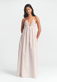 Maxi dress in light pastel colors with vertical stripes. Features a gathered bodice, deep neckline, and thin adjustable straps.