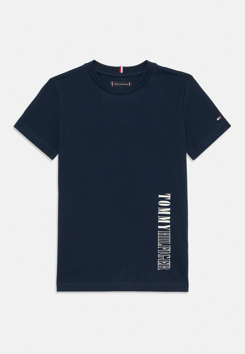 Mørkeblå bomullst-skjorte med korte ermer, med vertikal hvit tekst "TOMMY HILFIGER" langs venstre side og en liten logo på ermet.