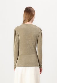 Olive green long-sleeve shirt with a soft, textured finish, featuring slight shoulder gathers and a round neckline.