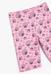 Lyserøde leggins med et skaldyr- og søstjernesprint i mørkeblå. Glat stof med en elastisk talje for komfort.