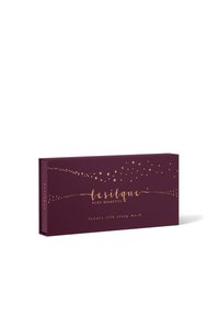 Fioletowe pudełko z złotym napisem i wzorem gwiazdek; oznaczone "le silque pure moments luxury silk sleep mask." Gładka tekstura, prostokątny kształt.