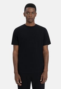Zwarte katoenen T-shirt met korte mouwen, ronde halslijn en een soepele textuur. Minimalistisch ontwerp zonder zichtbare patronen of logo's.