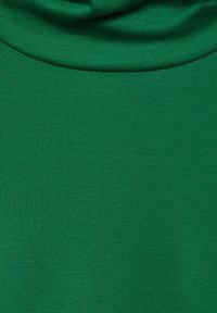 Grüstoffener, weicher Stoff mit einer glatten Textur, der einen drapierten Ausschnitt und ein durchgehendes Strickmuster aufweist. Keine sichtbaren Beschläge oder Akzente.