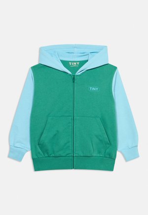 Børne-zip-hoodie med grøn krop, lyseblå ærmer og hætte, forlommer og "TINY" logo på brystet og inde i kraven.