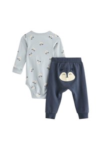 Hellblaues Bodysuit mit kleinen Fuchs-Mustern, kombiniert mit dunkelblauen Hosen, die auf der Rückseite einen Fuchs-Gesicht-Patch haben. Weicher Stoff, bequemer Sitz.