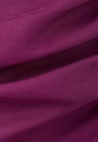 Fioletowa tkanina o gładkiej, ściśle tkanej strukturze oraz miękkich fałdach tworzących delikatne cienie i refleksy.