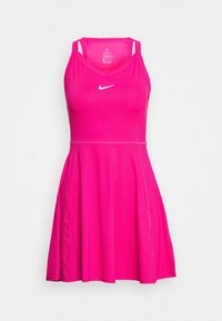 Robe de sport rose avec une texture côtelée, design dos nageur et logo Nike blanc sur la poitrine. Jupe évasée pour une silhouette ajustée.