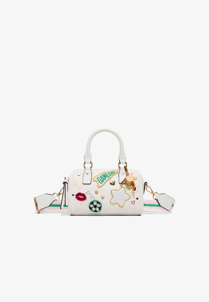 Sac à main blanc avec des poignées courtes et une bandoulière rayée, décoré de patches représentant une étoile, des lèvres, un ballon de football, un trophée, des cœurs et le texte "GAMEDAY".