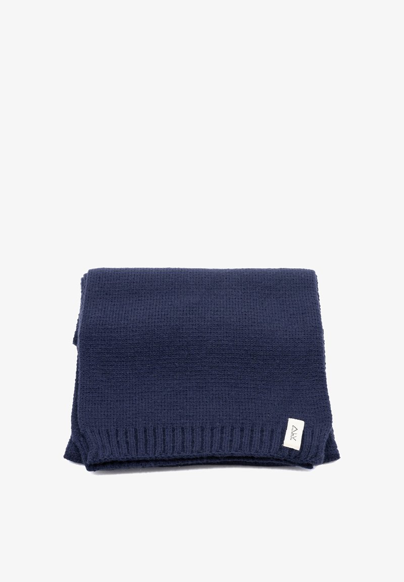 Coperta lavorata a maglia di colore blu navy con trama testurizzata, bordi a coste e una piccola etichetta in un angolo. Design morbido e caldo.