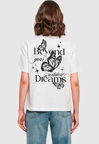 Witte katoenen t-shirt met zwarte bedrukte tekst en vlinderafbeeldingen op de achterkant. Korte mouwen en een relaxte pasvorm.
