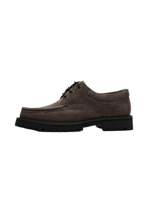 Chaussure en daim marron à lacets avec semelle épaisse noire crantée, œillets métalliques et détails cousus sur la partie supérieure.