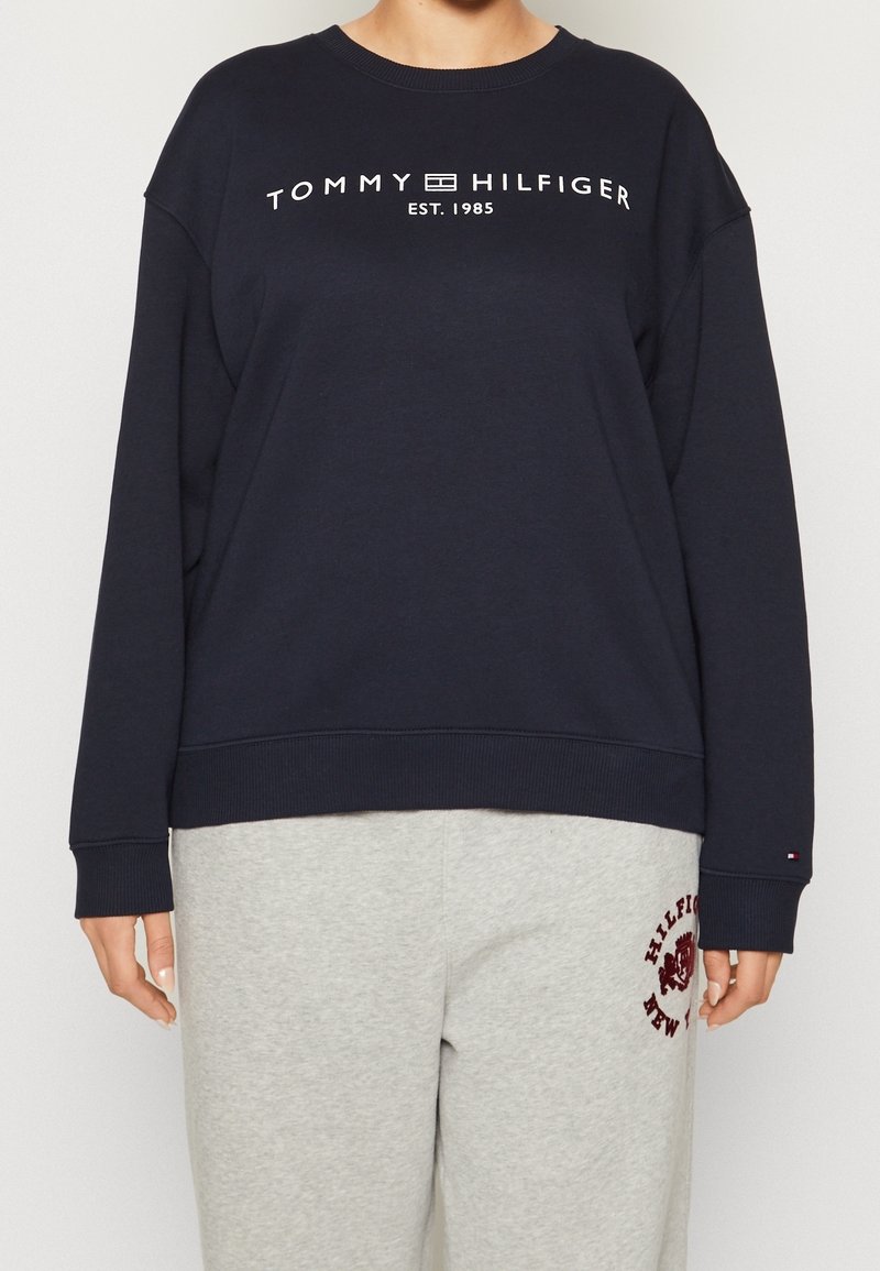 Felpa navy in misto cotone, presenta un collo a giro, spalle scese e una stampa bianca "TOMMY HILFIGER EST. 1985" sul petto.