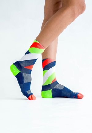 Multicolored ankle socks featuring geometric patterns in navy blue, white, bright green, and red with contrasting colored toe caps.