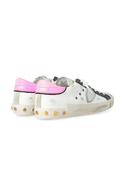 Sneakers bianche con accenti neri e argentati, linguetta del tallone rosa, superiore testurizzato, punta rotonda e borchie gialle su una suola testurizzata.