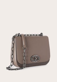 Bolso de mano de cuero marrón con un acabado suave, que presenta un detalle oscuro brillante, una correa de cadena y un emblema con logotipo en la parte frontal.