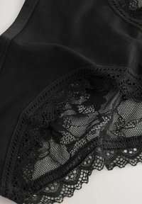 Zwarte panties van gladde stof met kantafwerking aan de randen, voorzien van ingewikkelde bloempatronen en geschulpte details.