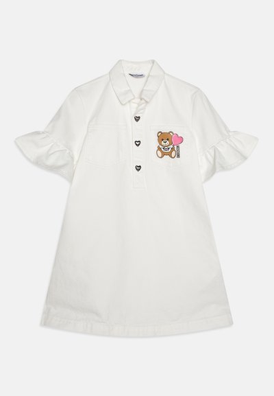 White cotton polo dress featuring a button placket, ruffled short sleeves, two chest pockets, and a bear graphic with a heart.