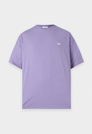 Camiseta lila de manga corta y cuello redondo con un pequeño logo blanco de Adidas trefoil en el pecho izquierdo, exhibida sobre un fondo liso y claro.