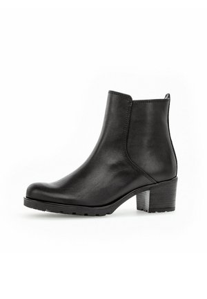 Botte chelsea en cuir noir avec un talon bloc et un bout rond, dotée de panneaux élastiques sur les côtés et d'une languette à l'arrière.