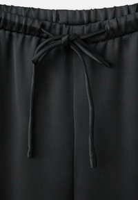 Schwarze Jogginghosen aus glattem Stoff mit elastischem Taillenbund und Kordelzugverschluss. Sie haben ein einfaches, schlankes Design.