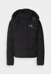 Zwarte pufferjas met een capuchon, geborduurd ontwerp en Calvin Klein-logo op de borst. Beschikt over een rits aan de voorkant en drukknopaccenten.