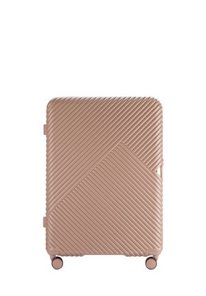Hard-shell suitcase in soft pink, featuring a diagonal ribbed pattern, smooth texture, and four spinning wheels for easy mobility.