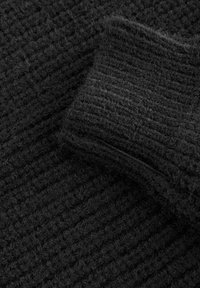 Tissu noir en tricot texturé avec un bord-côte côtelé. La surface est duveteuse, présentant un motif tissé dense. Convient pour la chaleur et le confort.