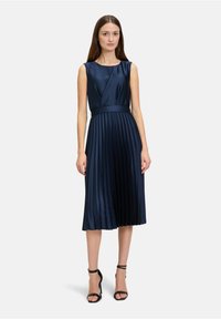 Navy Satin Faltenkleid mit tailliertem Oberteil, rundem Ausschnitt und betontem Taillenbereich. Verfügt über senkrechte Falten und eine Midi-Länge.