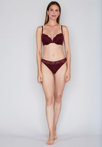 Bourgognefarvet blonde-bh med bøjle og bølget kant, kombineret med matchende blonde-bikini. Glat stof og delikate detaljer.