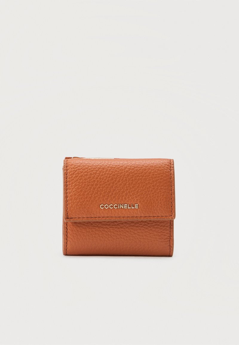 Μικρό δίπλωτο καφέ πορτοφόλι από δέρμα με υφή κόκκου και χρυσό λογότυπο "COCCINELLE" στην εμπρόσθια πτυχή.