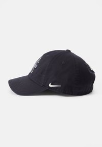 Navy plava pamučna kapica za bejzbol s zakrivljenim vizirijem, s bijelom vezom Nike logotipa i ventilacijskim otvorima na vrhu.