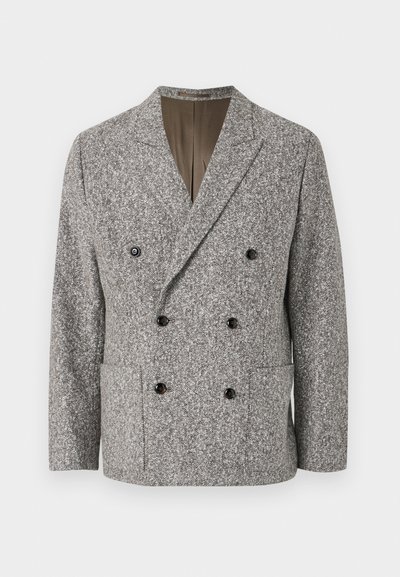 Dobbeltbrystet jakke i grå hørmønster med sorte knapper, en lapelkrave og to forlommer. Glat inderside.